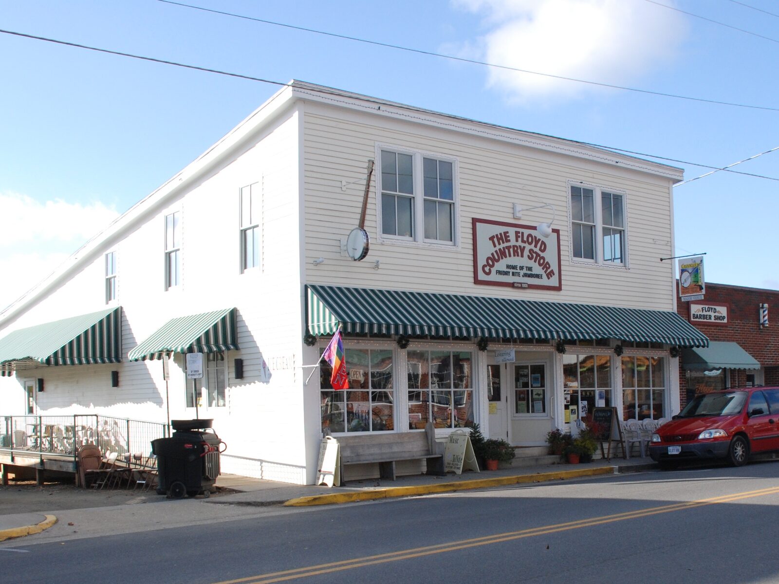 The Floyd Country Store's white two-story storefront on Locust Street, with green-striped awnings and a banjo mounted above the sign.